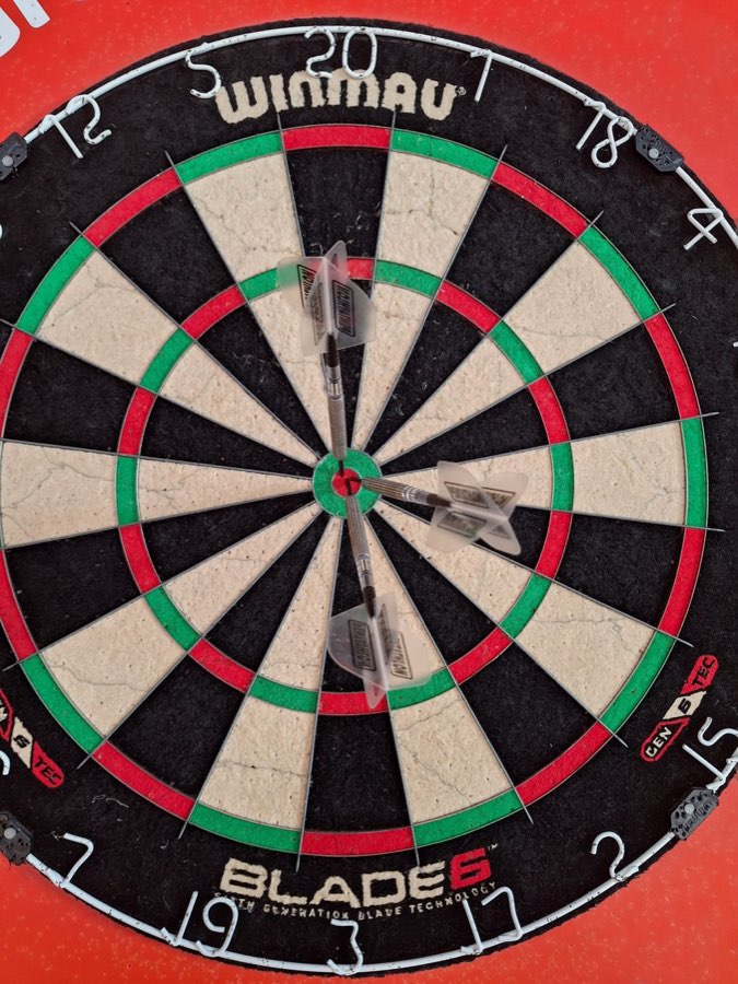 Dartpfeile im Bullseye einer Dartscheibe